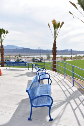 line of blue benches on a sidewalk