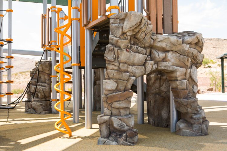 playground equipment with twisting pole and rock tunnel