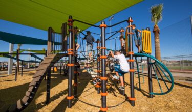 kid climbing up the side of equipment