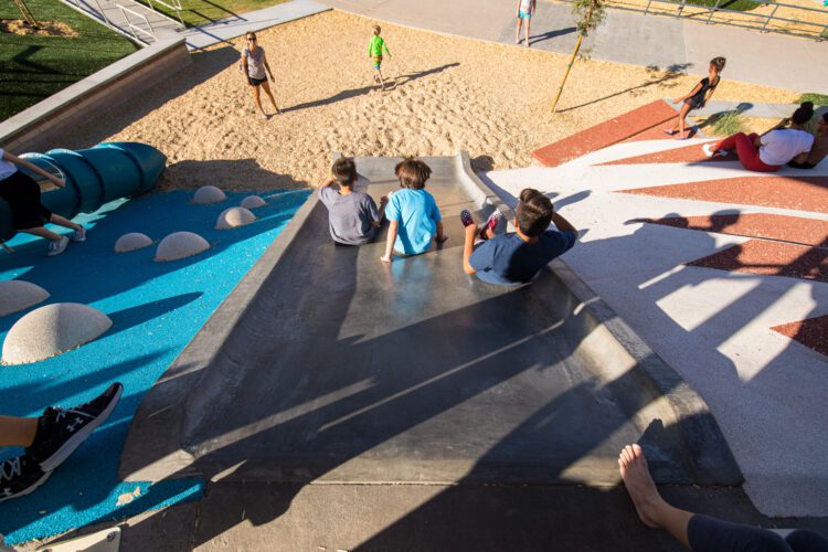 kids sliding down large slide