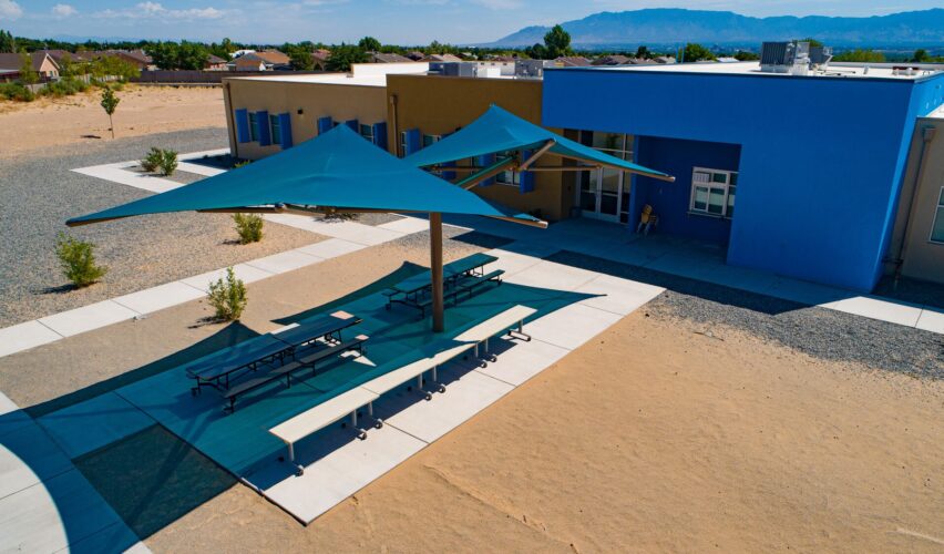 picnic tables with shades over them