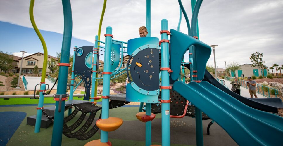 kid playing next to slide at the park