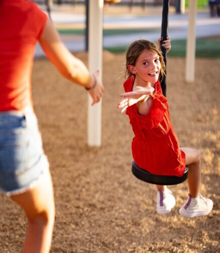 girl being pushed on a swing