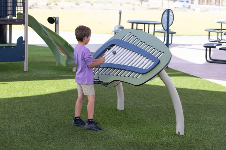 kid playing park instrument